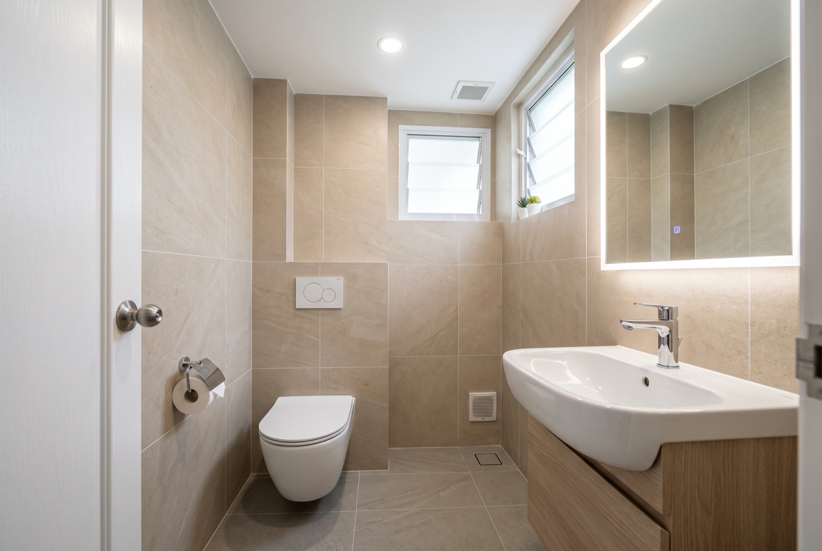 Freshly tiled HDB bathroom with new floor and wall tiles after an RK E&C toilet renovation in Singapore
